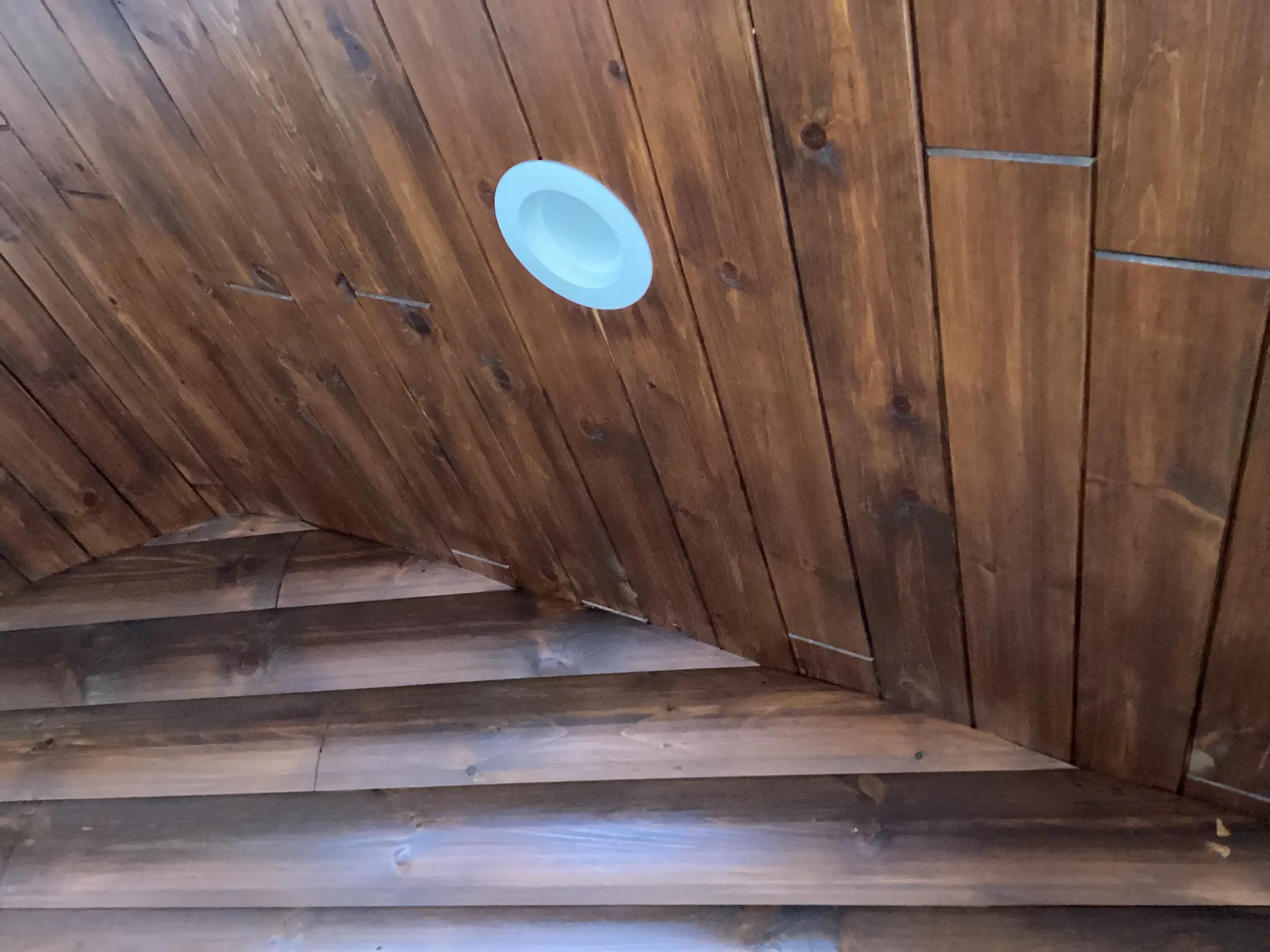 Stained tongue and groove pine ceiling detail inside a cabin loft