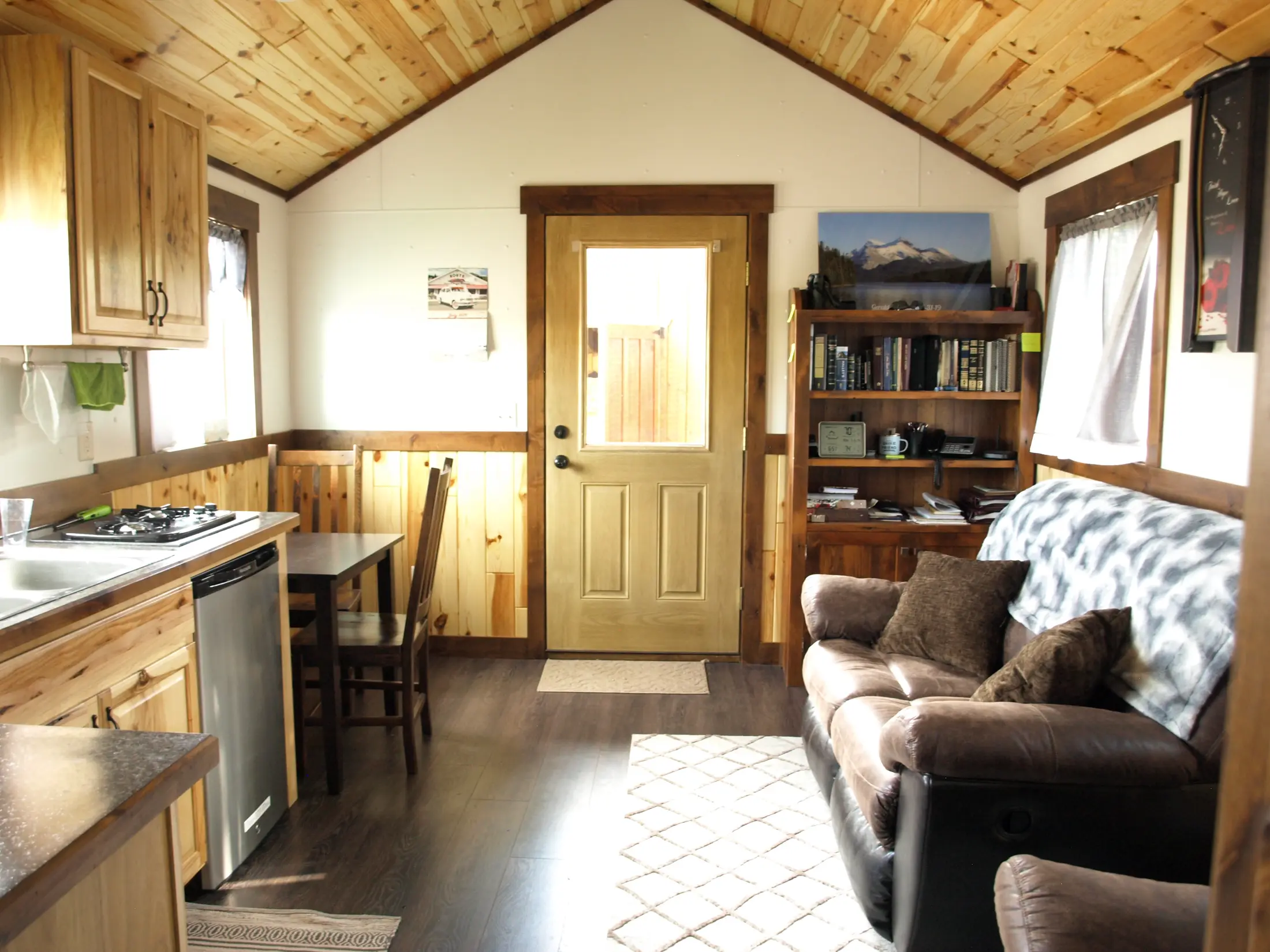 Furnished Stargazer living area with knotty pine ceiling, kitchenette, and dining table
