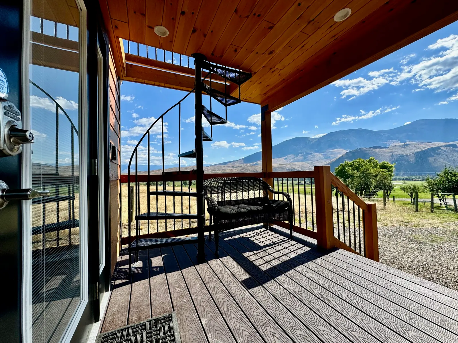 Stargazer covered deck with the spiral staircase to the rooftop deck and mountains behind